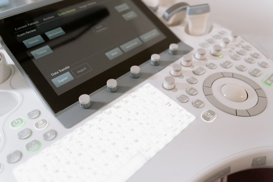 Detailed view of a medical ultrasound machine control panel with buttons and screen.