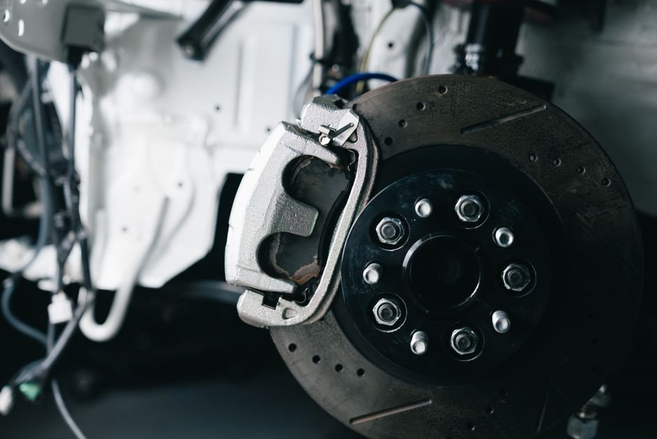 prepare part for 3D scanning — Detailed view of a car's brake caliper and disc in a workshop setting